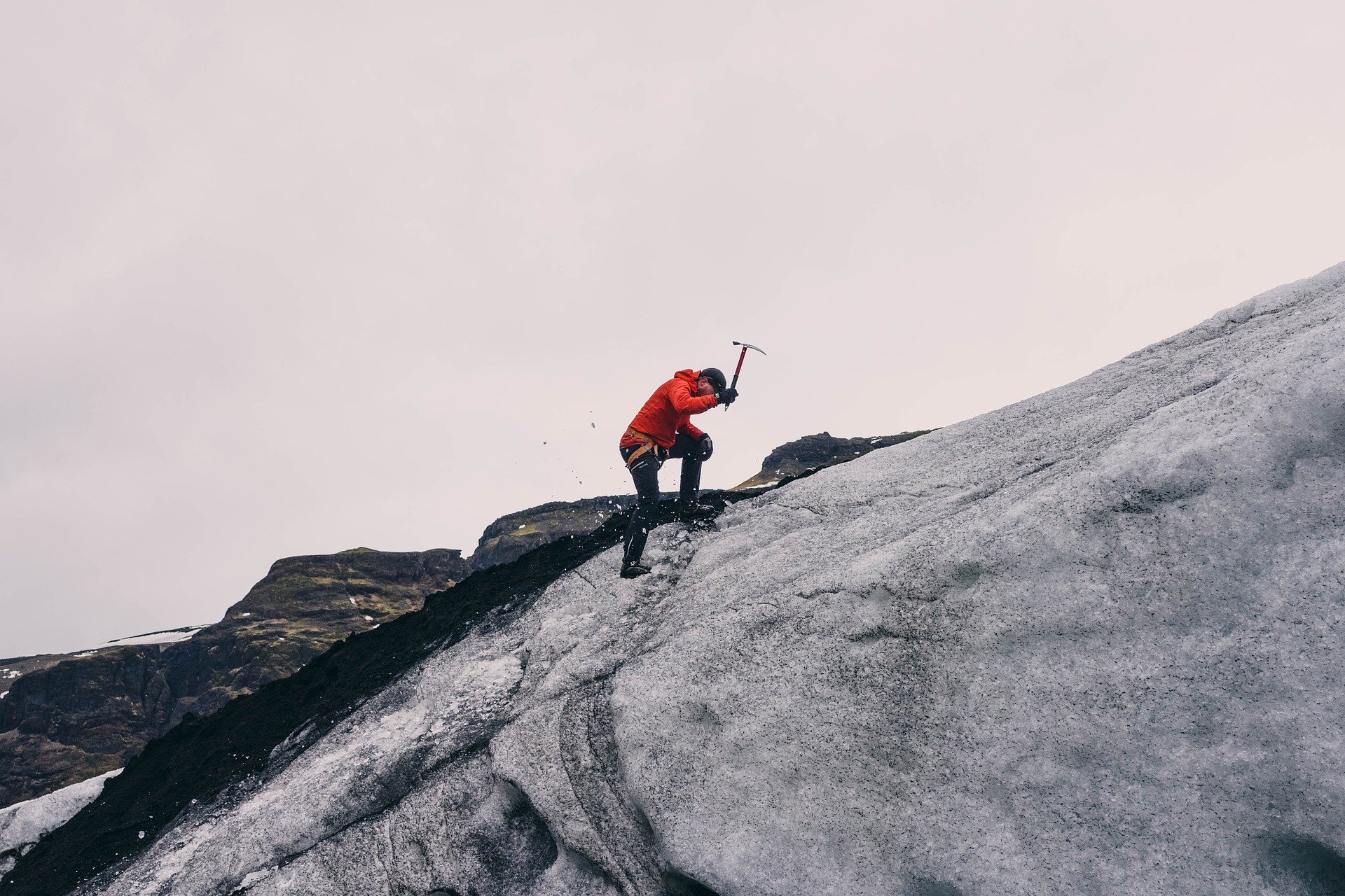 Hombre con ropa térmica picando con un pico en una montaña